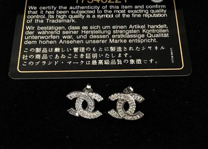 Authentic Chanel stud earrings with 925 sterling silver and baguette white zircon stones on black background