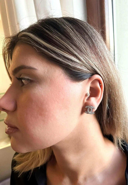 Authentic Chanel stud earrings in 925 sterling silver with baguette white zircon stones worn by woman
