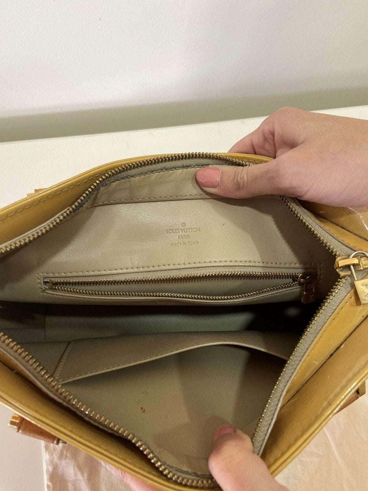 Interior view of authentic yellow Louis Vuitton Vernis Houston purse bag showing zipper pocket and beige lining