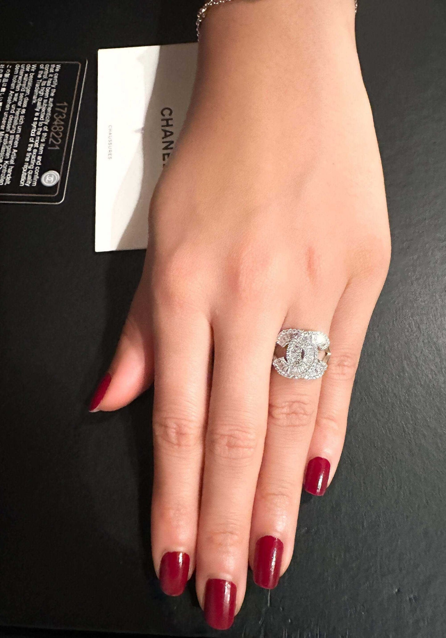 925 Sterling Silver Chanel ring with zircon stone on hand with red nail polish